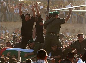 The coffin containing the remains of Palestinian leader Yasser Arafat is carried over the heads of the crowd
