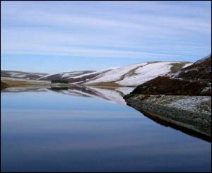 Rolling hills reflecting in the Graig Goch reservoir (Elan valley) after a snow shower, by Andrew Almond from Oxford