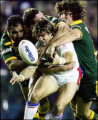 Brian Carney is tackled by three Australians as he tries to offload the ball