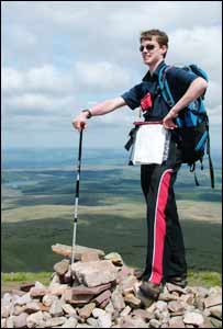Aaron Jones, of Pontardawe, standing on a cairn on the summit of Fan Foel, near Llyn Y Fan Fawr