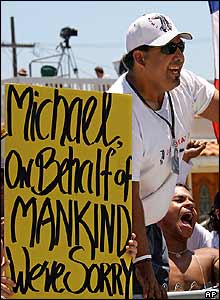 Man holding poster saying world is sorry