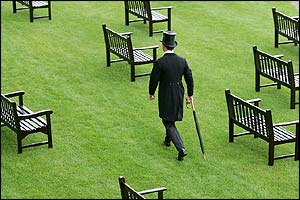 A racegoer walks through a sea of empty benches