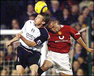 Manchester United's Mikael Silvestre (R) fights for the ball next to Fulham's Brian McBride 