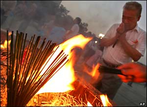 A man prays by incense at Hiroshima