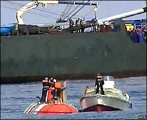 A navy launch alongside the mini-submarine after it surfaces 