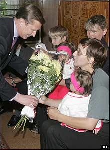 Defence Minister Sergei Ivanov (left) gives flowers to the submarine commander's wife