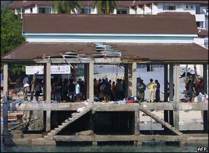 Tourists and workers wait at the jetty on the Phi Phi island in southern Thailand holiday resort which was destroyed by the tsunami