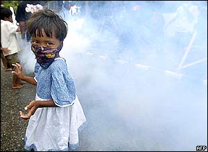 A child staying at a refugee camp wears a mask made of a piece of fabric as they area is fumigated in Banda Aceh, 01 January 2005.