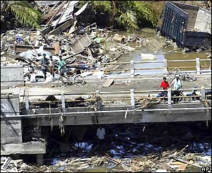 Indonesian villagers stand amid the ruins of Kuede Teunom, 2 Jan