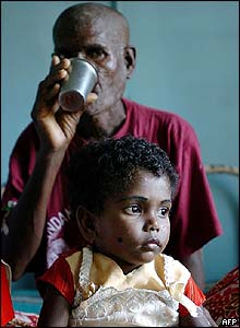 Refugee at hospital in Port Blair drinks water with his granddaughter