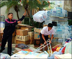 Workers in Bangkok, Thailand, load boxes of aid into trucks