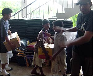 Young children in Sri Lanka load boxes in their home for victims of tsunami