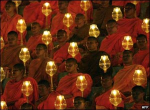 Buddhist monks hold candles during a memorial service in Thailand