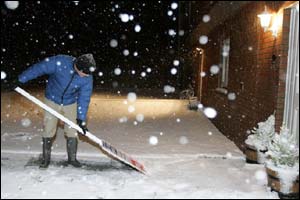 Man clearing snow with a For Sale sign