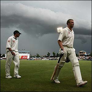 Andrew Flintoff walks off the field as bad light stops play