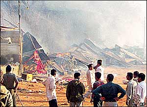 Crowds look on at burning buildings in the temple complex