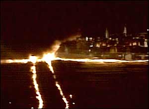 Rail tracks lit up in two ribbons of flame at the camp
