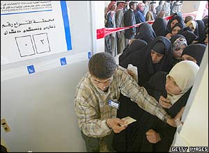 Voters queue to enter a polling station in Najaf