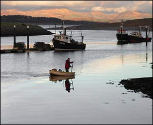 A lone fisherman returns to shore with Snowdon bathed in evening sun behind (Julian Triggs) 