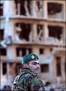 Damaged buildings behind a Lebanese security force member