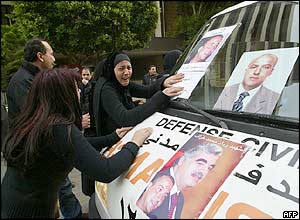 Grieving Lebanese touch the ambulance carrying the body of one of Rafik Hariri's bodyguards, also killed in the blast