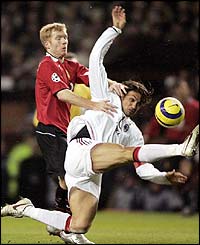 Manchester United's Paul Scholes challenges Paolo Maldini