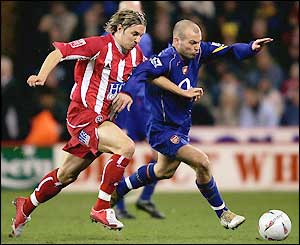 Arsenal's Swedish midfielder Freddie Ljungberg is challenged by Phil Jagielka 