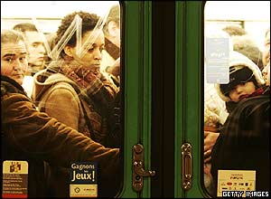 Commuters crowd onto a metro train in Paris, France