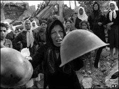 Palestinian survivors show helmets of those they say attacked them at memorial service on 27 September 1982