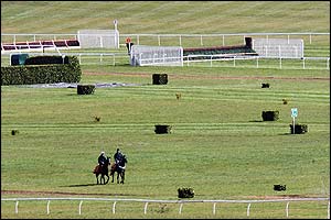 Two horses compete in a workout on the course