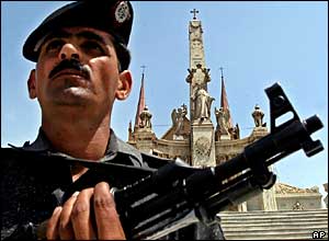 A police officer stands guard with an assault gun at the St. Patrick church in Karachi, Pakistan 