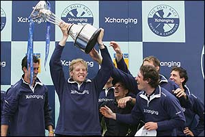 Oxford's Andrew Triggs Hodge lifts the winning trophy