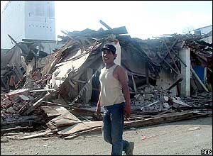 A man walks past ruined buildings in Peunayong, Aceh
