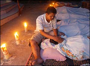 Dr Haegombowo nurses the dead body of his wife Lisbet Sihanturi at a makeshift morgue
