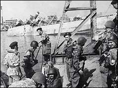 Soldiers with sinking ship in background