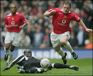 Wayne Rooney leaps over the challenge of Newcastle's Amdy Faye 