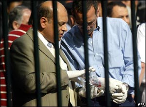 Egyptian forensic experts and security men check remains of a body at the site of the blast behind the Egyptian museum in Cairo.