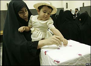 Iranian woman votes while holding her daughter in her arms