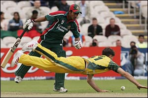 Ashraful (L) watches Brad Hogg (R) dive for the ball