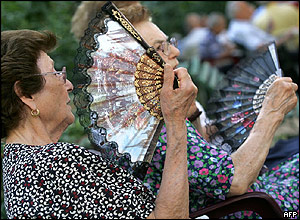 Women use fans in a garden in Rome