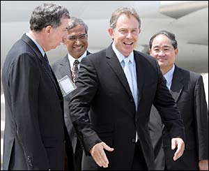 British Prime Minister Tony Blair (C) is greeted by British High Commissioner Alan Collins (L) and Singapore's Minister of State for Foreign Affairs Zainul Abidin Rasheed 