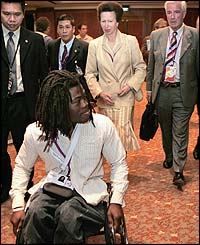 Britain's Princess Anne (c-behind) and British IOC member Craig Reedie (r-behind) follow British paralympic athlete Ade Adepitan (front)