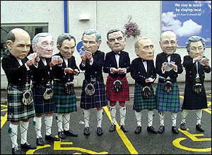 Protesters with heads of the world leaders meeting at the G8 summit