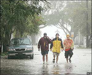 Key West residents walk through a flooded street 