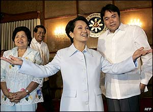 Philippine President Gloria Arroyo (C) gestures while meeting with local government officials before a luncheon at the Malacanang presidential palace in Manila, 13 July 2005. 