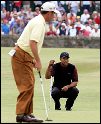 Woods watches Olazabal putt on the first green