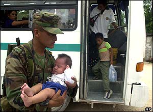 A Mexican soldier carries a baby into a shelter