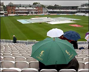 A few hardy spectators survey the scene from the Edrich Stand at Lord's