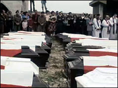 Coffins draped with flags at funeral service in Maiano