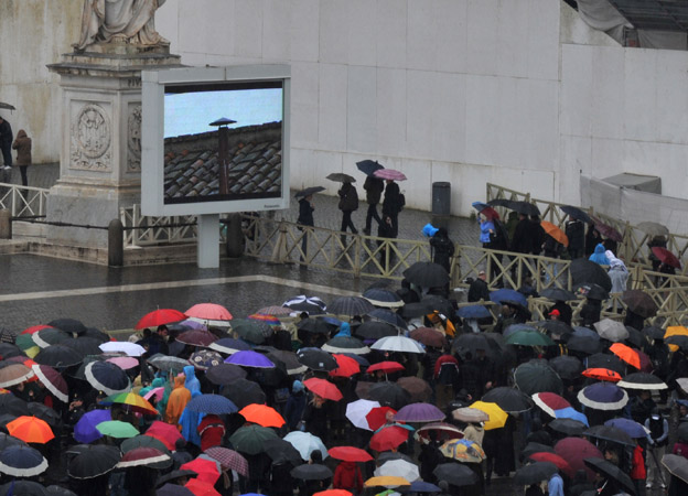 Onlookers watching big screen